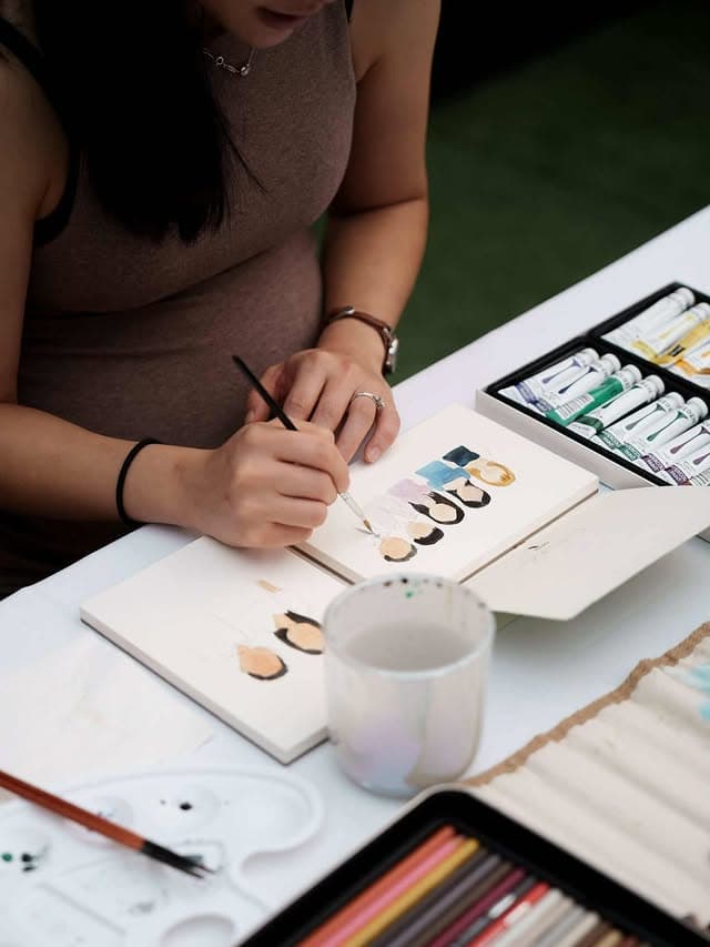 Yui sketching character portraits at the studio